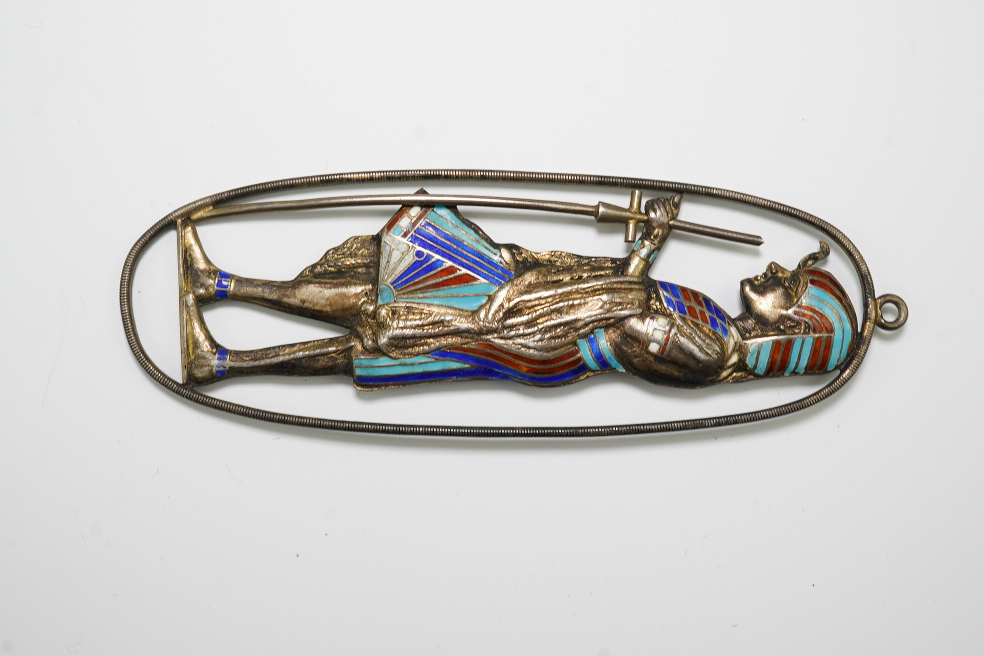 An Egyptian Revival silver and enamelled oval pendant, 88mm and a silver enamelled stylised butterfly brooch.